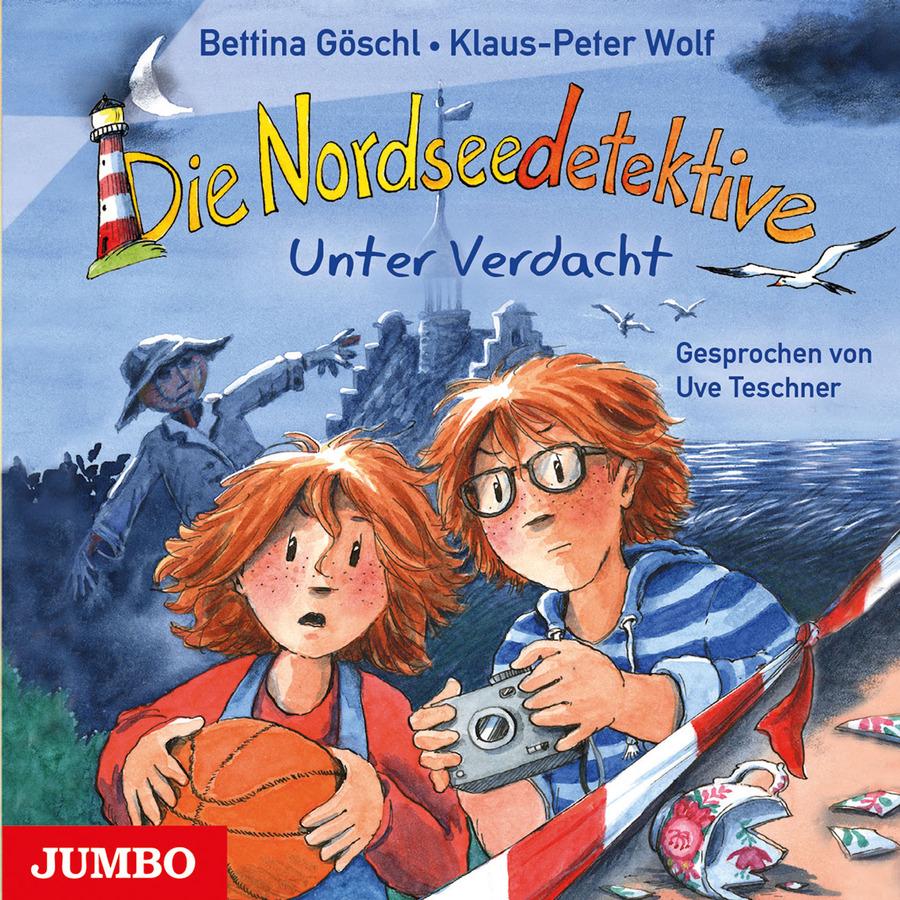 „Die Nordseedetektive – Unter Verdacht“ von Bettina Göschl und Klaus-Peter Wolf: Illustriertes Cover mit einer nächtlichen Szene an der Nordsee. Im Vordergrund stehen zwei rothaarige Kinder hinter rot-weißem Absperrband. Das Mädchen hält einen Basketball in den Armen und schaut erschrocken nach vorne. Der Junge mit Brille und blau-weiß gestreiftem Kapuzenpullover hält eine Kamera in beiden Händen und blickt ebenfalls besorgt. Rechts unten liegen Scherben eines zerbrochenen Porzellangefäßes mit Blumenmuster auf dem Boden. Im Hintergrund stehen Meer und eine dunkle Burg, davor eine unheimliche Vogelscheuche mit ausgestrecktem Arm. Möwen fliegen über der Szene, links oben ist ein Mond zu sehen. Oben stehen die Autorennamen und der Reihenname „Die Nordseedetektive“, darunter der Titel „Unter Verdacht“. Rechts steht „Gesprochen von Uve Teschner“, unten links das Logo „JUMBO“.